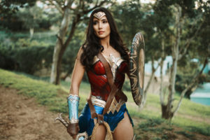 cosplay wonder woman complet avec armure rouge, bouclier doré et tiare dans une forêt