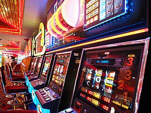 rangée de machines à sous illuminées dans un casino avec néons colorés