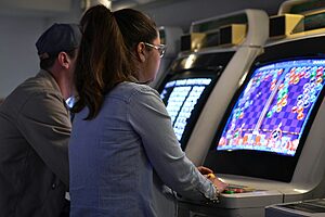 femme jouant à un jeu vidéo rétro sur borne arcade colorée